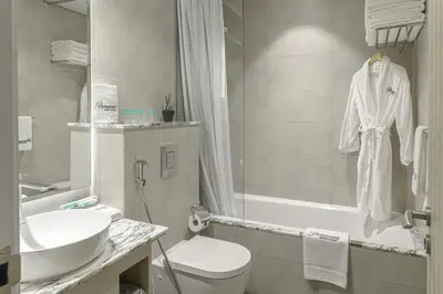 a bathroom with a sink and a toilet and a bath tub at Paramount Tower Hotel and Residences with Infinity Sky Pool in Dubai