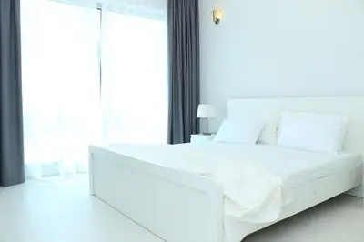 a white bed with white sheets and pillows in a bedroom at Dubai Marina larivera in Dubai