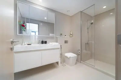 a white bathroom with a toilet and a shower at Vogue Downtown Burj Royale near Dubai Mall and Burj Khalifa ,Two Bedroom Apartment with large Balcony and Access to all Amenities in Dubai