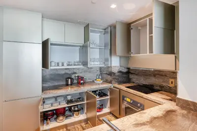 a kitchen with white cabinets and marble counter tops at Luxury 2BR Panoramic Marina Views High Floor in Dubai