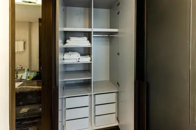 a walk in closet with white drawers and towels at Luxury 2BR Panoramic Marina Views High Floor in Dubai