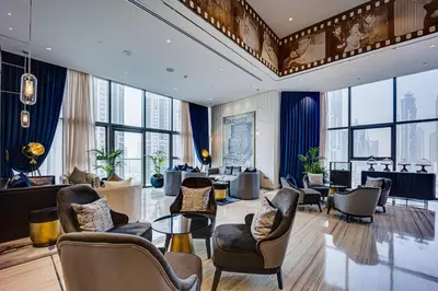 a hotel lobby with chairs and tables and windows at Elegant apartment in Paramount Midtown residence in Dubai
