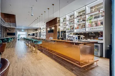 a restaurant with a long bar with green chairs at Elegant apartment in Paramount Midtown residence in Dubai