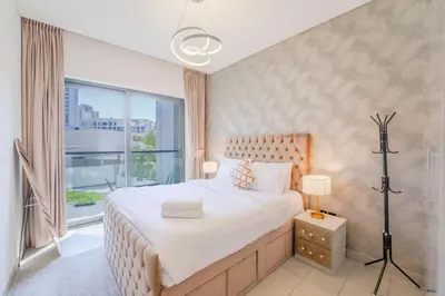 a bedroom with a large bed and a large window at EasyGo - Sobha Waves 1 Bedroom & Study Modern in Dubai