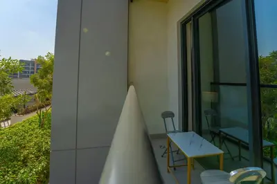 a room with a table and chairs on a building at EasyGo - Sobha Waves 1 Bedroom & Study Modern in Dubai