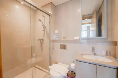 a bathroom with a shower and a toilet and a sink at EasyGo - Sobha Waves 1 Bedroom & Study Modern in Dubai