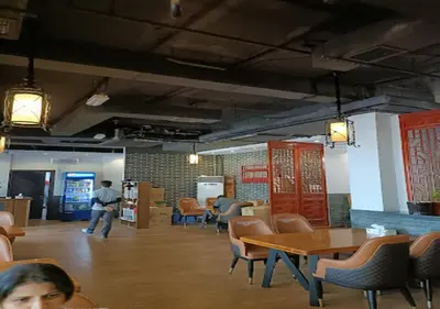 a man sitting in a restaurant with tables and chairs at Cosmos Living Spacious with Balcony GCV1 in Dubai