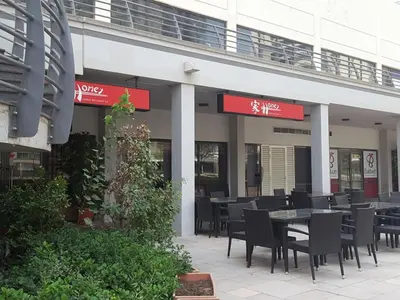 a restaurant with tables and chairs in front of a building at Cosmos Living Spacious with Balcony GCV1 in Dubai
