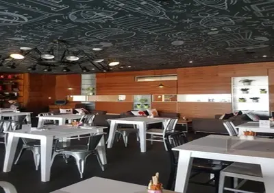 a restaurant with white tables and chairs and a patterned ceiling at Cosmos Living Spacious with Balcony GCV1 in Dubai