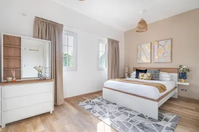 a bedroom with a bed and a dresser and windows at GuestReady - Springs Serenity near Golf Club in Dubai