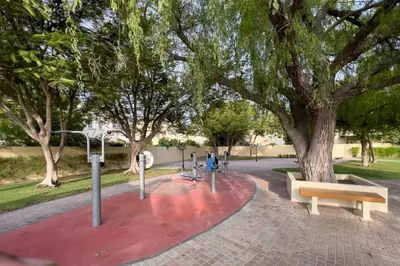 a park with two benches and a tree at GuestReady - Springs Serenity near Golf Club in Dubai