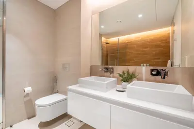 a bathroom with two sinks and a toilet and a mirror at GuestReady - Majestic Ain Dubai from your balcony in Dubai