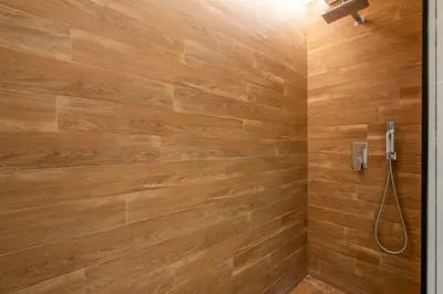 a bathroom with a shower with a wooden wall at GuestReady - Majestic Ain Dubai from your balcony in Dubai