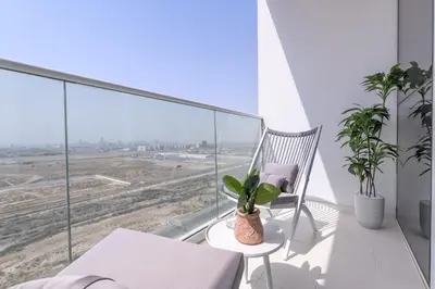 a balcony with a chair and a table with plants at Executive Studio in Damac Hills by Suiteable in Dubai