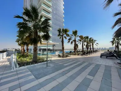 a walkway with palm trees and a building at Executive Studio in Damac Hills by Suiteable in Dubai