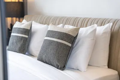a group of pillows sitting on top of a bed at Canal front apartment with Burj Khalifa view by Suiteable in Dubai