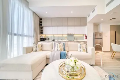 a living room with a couch and a table at Polished 1BR at Noor 1 Midtown Dubai Production City by Deluxe Holiday Homes in Dubai