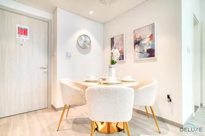 a dining room with a table and chairs at Polished 1BR at Noor 1 Midtown Dubai Production City by Deluxe Holiday Homes in Dubai
