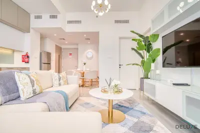 a living room with a couch and a table at Polished 1BR at Noor 1 Midtown Dubai Production City by Deluxe Holiday Homes in Dubai