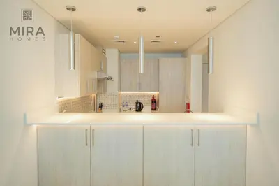 a kitchen with white cabinets and a white counter top at Mira Holiday Homes - Lovely 1 bedroom with beach access in Dubai