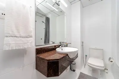 a bathroom with a sink and a toilet and a mirror at Special Rates - Elegant Studio - Golf Views in Dubai