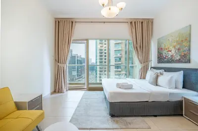 a bedroom with a bed and a large window at RH- Studio Retreat, Walk away to Burj Khalifa and Dubai Mall in Dubai