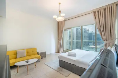 a bedroom with a bed and a couch and a large window at RH- Studio Retreat, Walk away to Burj Khalifa and Dubai Mall in Dubai