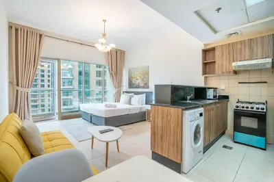 a kitchen and living room with a couch and a bed at RH- Studio Retreat, Walk away to Burj Khalifa and Dubai Mall in Dubai