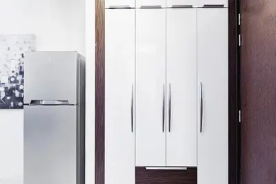 two white refrigerators standing next to each other at Waves Holiday Homes - Chic Studio With Balcony Overlooking City Views in Dubai