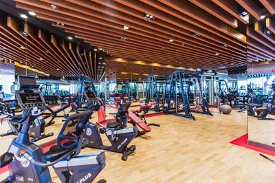 a gym with a bunch of cardio machines in it at Waves Holiday Homes - Chic Studio With Balcony Overlooking City Views in Dubai