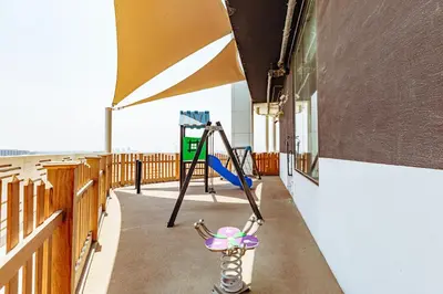 a playground in a building with a swing at Waves Holiday Homes - Chic Studio With Balcony Overlooking City Views in Dubai