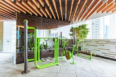 a gym with green equipment in a building at Waves Holiday Homes - Chic Studio With Balcony Overlooking City Views in Dubai