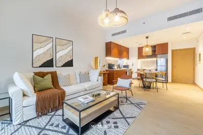 a living room with a couch and a table at Manzil - 1BR Home in Port de la Mer w Lake Access in Dubai
