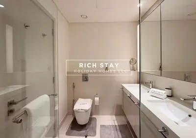 a bathroom with a toilet and a sink and a mirror at Sunrise Bay 3BR EMAAR Beachfront Dubai Harbour by Rich Stay in Dubai