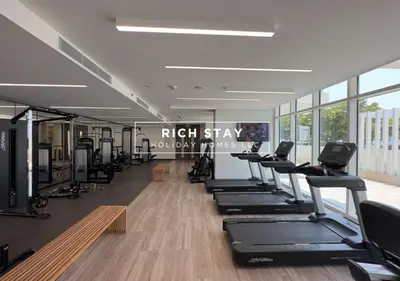 a gym with a row of treadmills and machines at Sunrise Bay 3BR EMAAR Beachfront Dubai Harbour by Rich Stay in Dubai