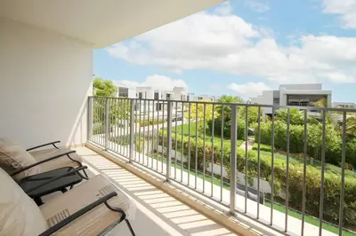 a balcony with chairs and a view of a building at NewArabian Dubai Hills Sidra Villa in Dubai