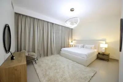 a bedroom with a large white bed and a table at NewArabian Dubai Hills Sidra Villa in Dubai