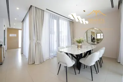 a dining room with a table and chairs and a mirror at NewArabian Dubai Hills Sidra Villa in Dubai