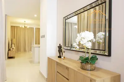 a living room with a large mirror on the wall at NewArabian Dubai Hills Sidra Villa in Dubai