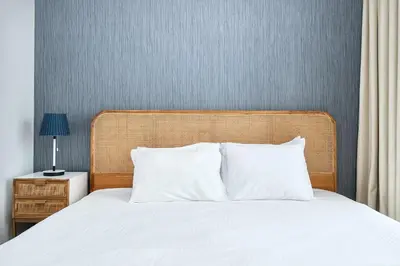 a bed with white sheets and a wooden headboard at BellaVista Downtown Views II Tower 1 Modern 2BR Downtown City View in Dubai