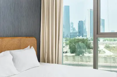 a bedroom with a bed and a large window at BellaVista Downtown Views II Tower 1 Modern 2BR Downtown City View in Dubai
