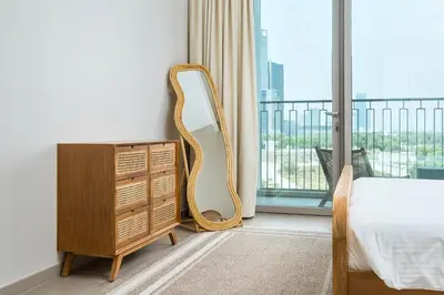 a bedroom with a dresser and a mirror next to a window at BellaVista Downtown Views II Tower 1 Modern 2BR Downtown City View in Dubai