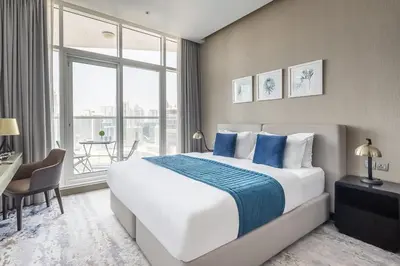 a bedroom with a bed and a desk and a window at Frank Porter - Prive A in Dubai