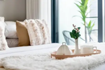 a tray with cups and a vase with flowers on a bed at GuestReady - A sophisticated and refined dwelling in Dubai