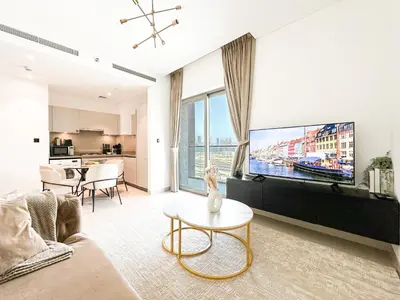 a living room with a couch and a tv at Trophy - Maison de Charme Suite in Dubai
