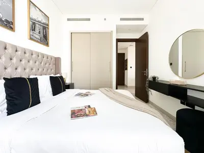 a bedroom with a large white bed with a large mirror at Trophy - Maison de Charme Suite in Dubai