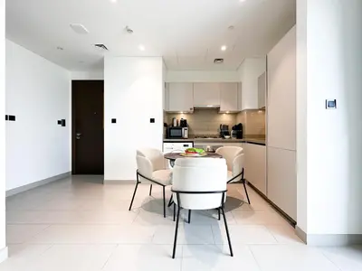 a kitchen and dining room with a table and chairs at Trophy - Maison de Charme Suite in Dubai