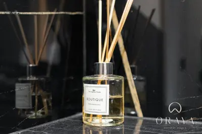 a bottle of perfume sitting on a table with sticks at Oraya - Studio With Jaw-Dropping Canal and Burj Views - Business bay in Dubai