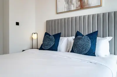 a bedroom with a white bed with blue pillows at Welcome Home Apartments - VIDA Marina - Full Marina view - High Floor in Dubai