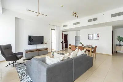 a living room with a gray couch and a table at Frank Porter - Bahar 1 in Dubai